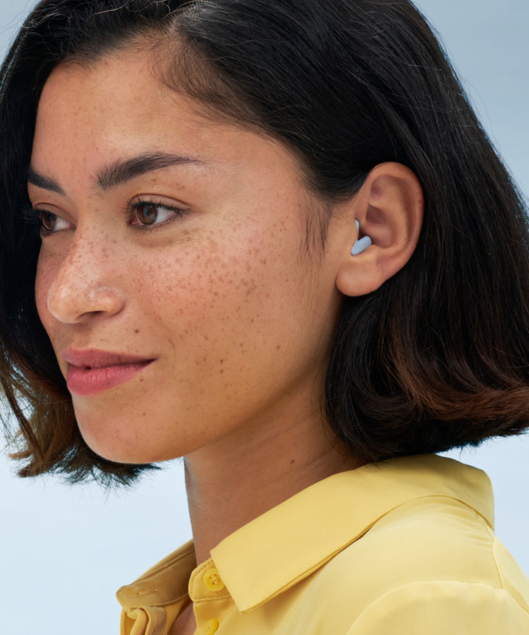 Eine lächelnde Frau trägt Alpine Silence Blue.